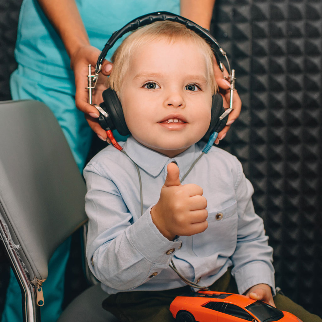 network hearing child giving thumb up during hearing test